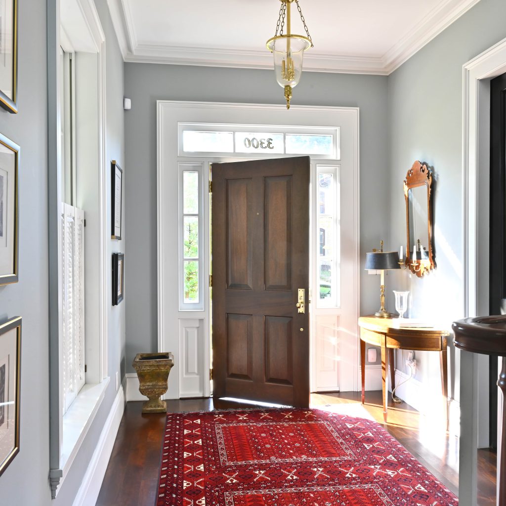Historic-style solid wood entry door with traditional panel design and brass hardware, custom-built by Rockwood Door & Millwork for a classic home renovation.