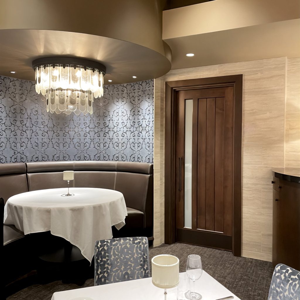 Custom interior wood door by Rockwood Door & Millwork featured in the upscale dining space at Eddie V’s Prime Seafood.