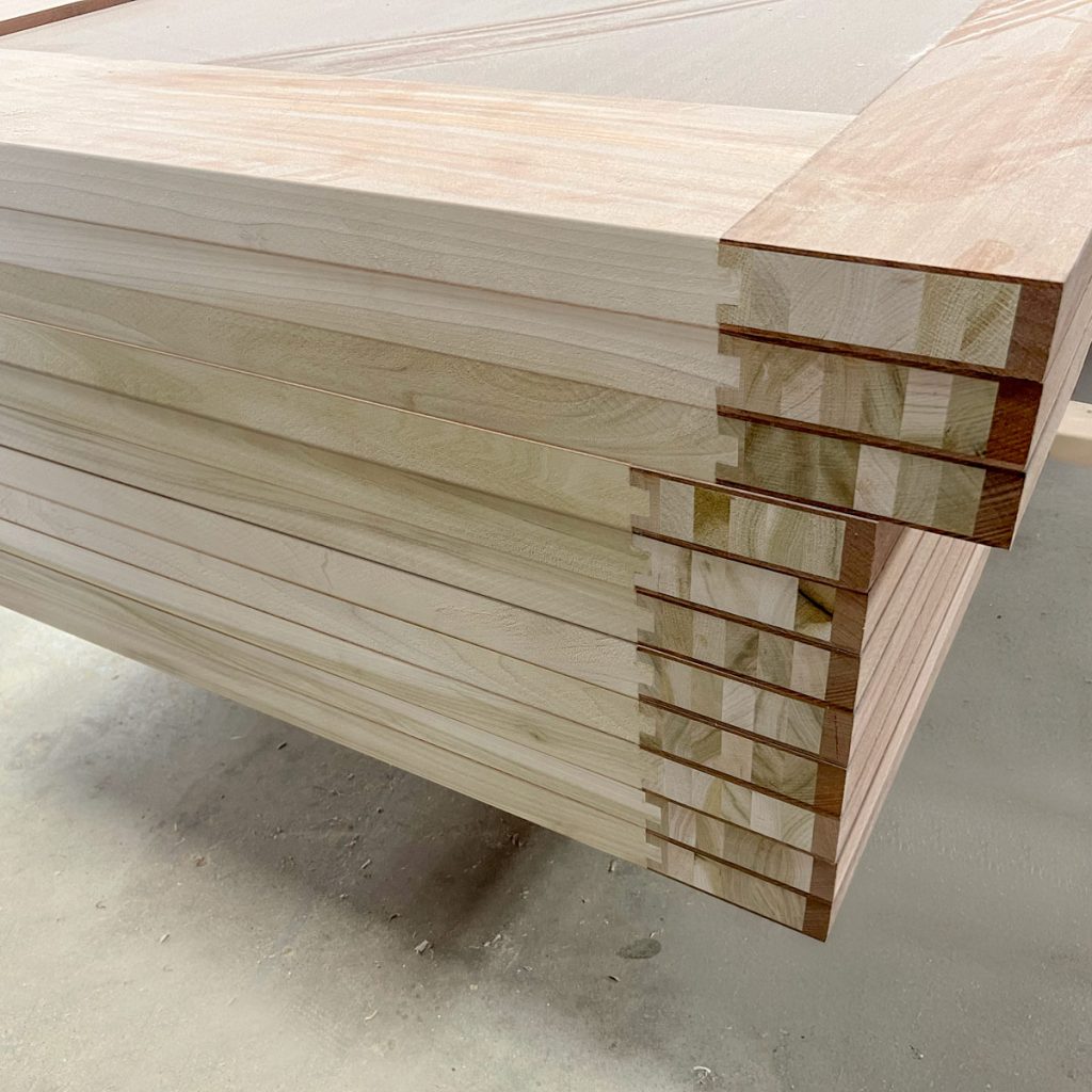 Stack of unfinished stave core door panels with laminated hardwood construction, built for strength and stability at Rockwood Door & Millwork in Millersburg, Ohio.