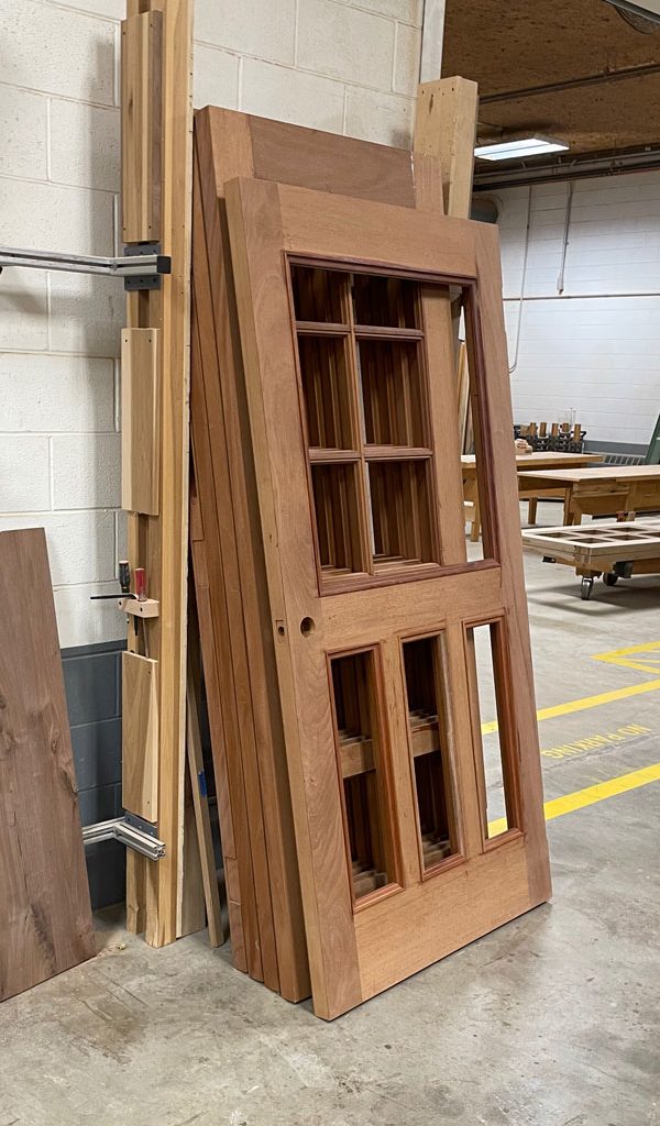 Unfinished solid mahogany exterior doors in production at Rockwood Door & Millwork’s shop in Millersburg, Ohio, known for durability and elegance.