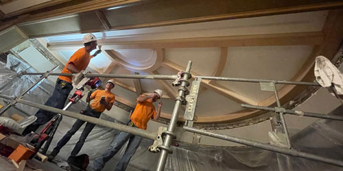 Rockwood millwork team installing custom curved ceiling beams at the Athletic Club of Columbus, using scaffolding to access the historic interior architecture.