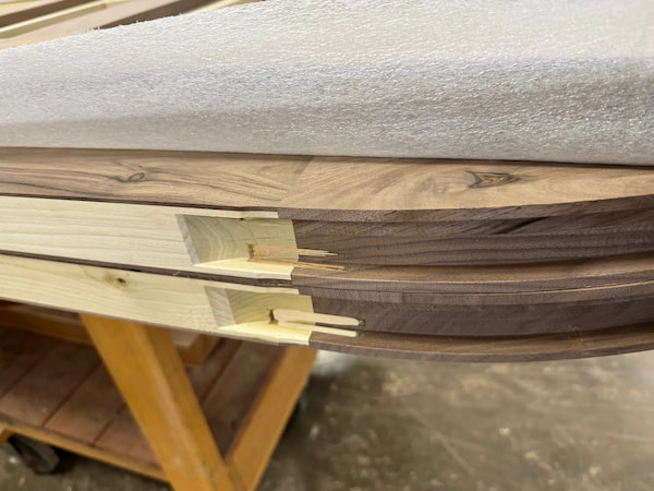 Joinery detail showing interlocking curved sections of walnut trim, part of Rockwood’s custom millwork for arched interior openings.